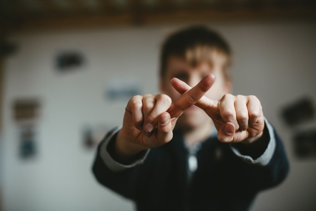 man making an x with his fingers